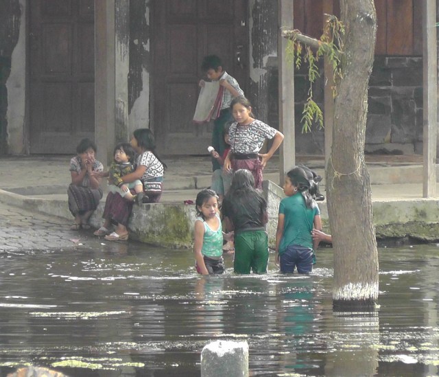 Local children splashing around in Lago de Atitlán near Santiago