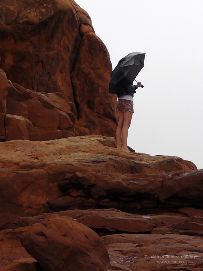 foggy arches national park girl umbrella monsoon season utah watching standing