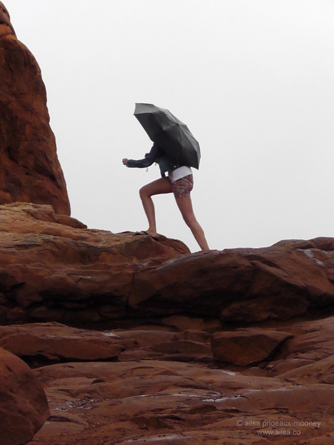 foggy arches national park girl umbrella monsoon season utah walking climbing
