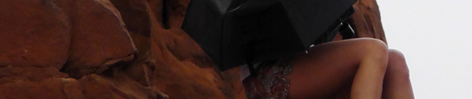 solitary girl arches national park utah umbrella monsoon season