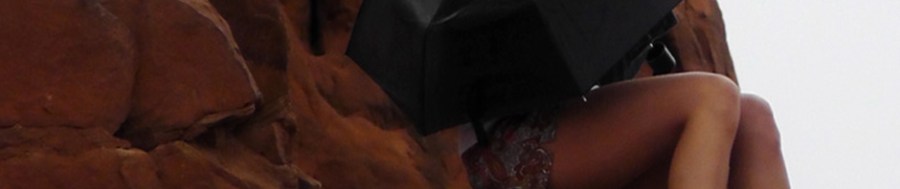 solitary girl arches national park utah umbrella monsoon season